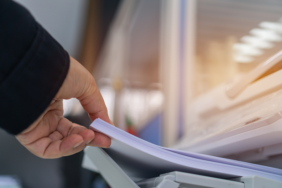 Business Printer / Printing Documents In Office Concept: Busines Business printer / printing documents in office concept: Businessman press white paper in laser printed cartridge feeder, scanner machine for copy document to report in busy modern offices background
