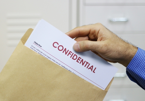 bigstock-Man-Handling-Confidential-Docu-40391122 Cropped view image of a man handling confidential documents placing them inside a brown manilla envelope for mailing