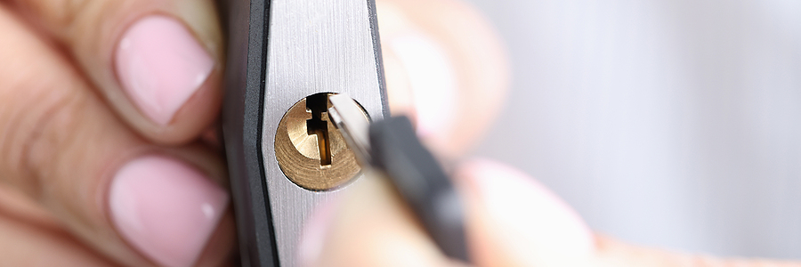Closeup of hand holding keys and lock for securing a collection container