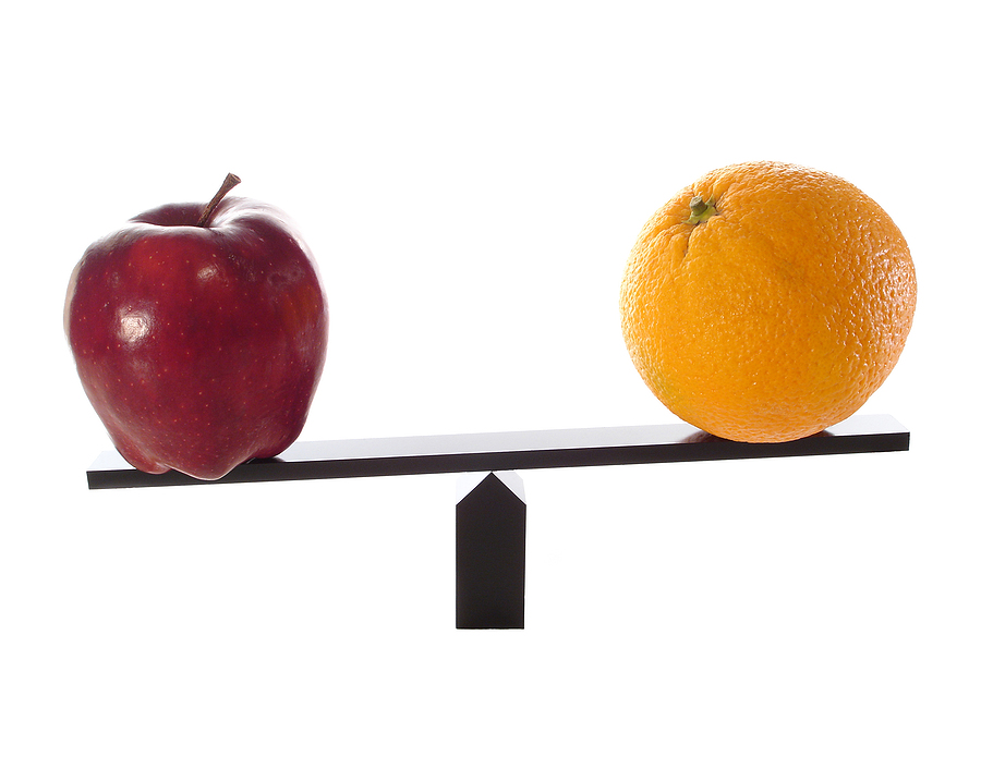 An apple and an orange balanced on opposite ends of a balance beam.